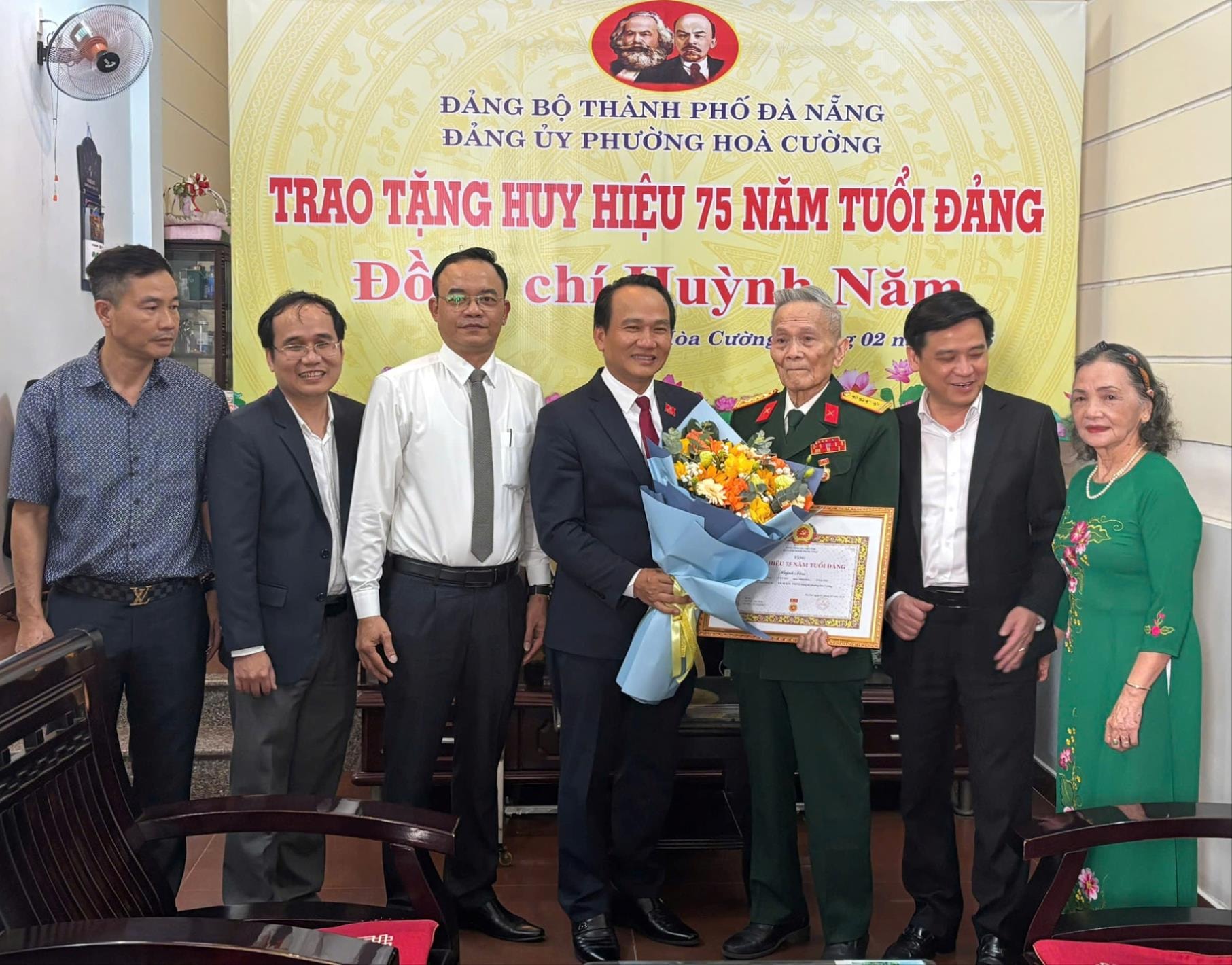 Phó Bí thư Thường trực Thành ủy Nguyễn Đình Vĩnh (giữa) trao Huy hiệu 75 năm tuổi Đảng cho đồng chí Huỳnh Năm. Ảnh: PV