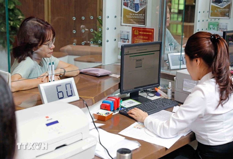 Khách hàng giao dịch tại Hội sở Vietcombank ở Hà Nội. (Ảnh: Trần Việt/TTXVN)