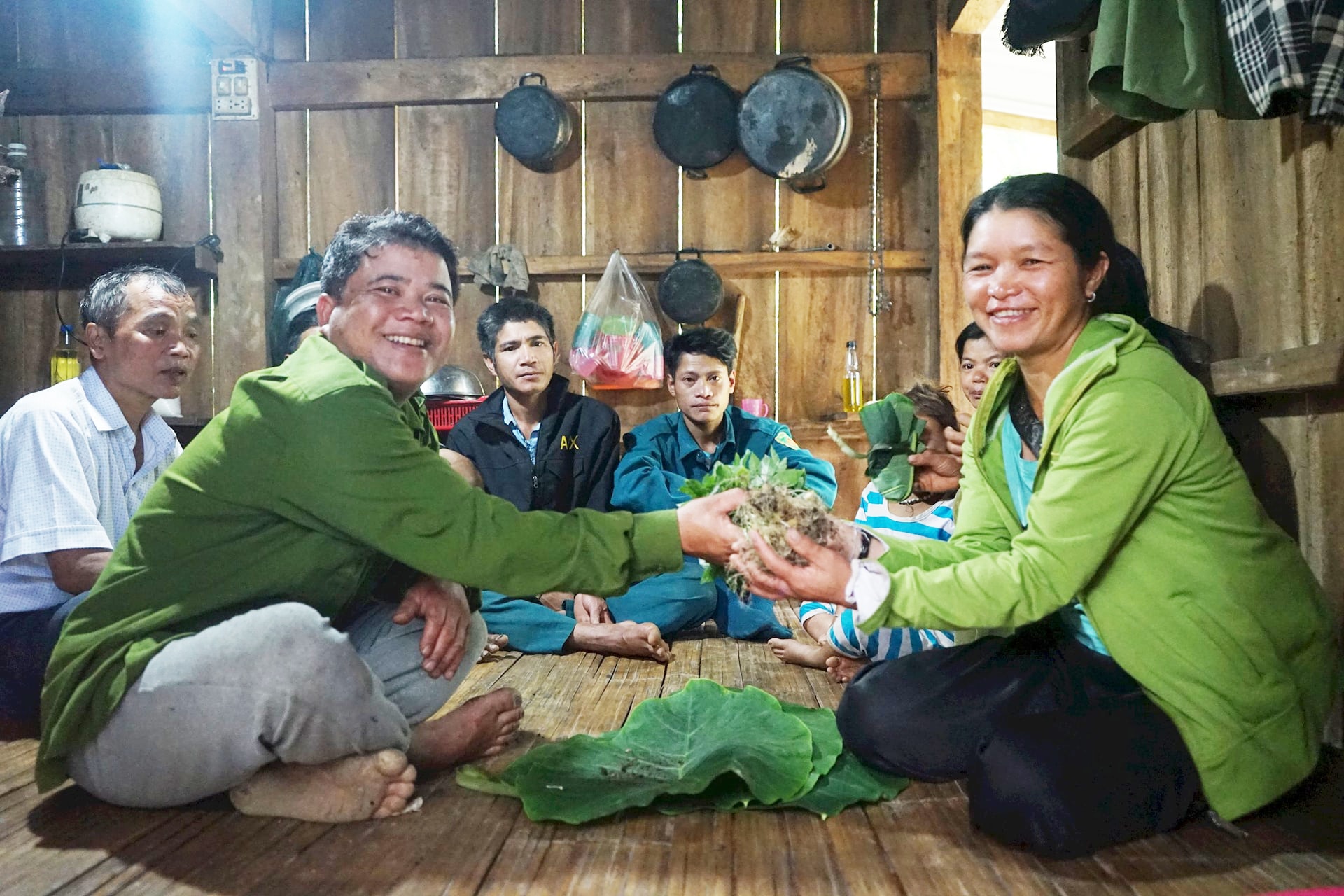 Ông Hồ Văn Đuôi (thứ 2, bên trái sang) trao cây sâm giống cho bà con nghèo trong thôn. Ảnh: PHÚ THIỆN