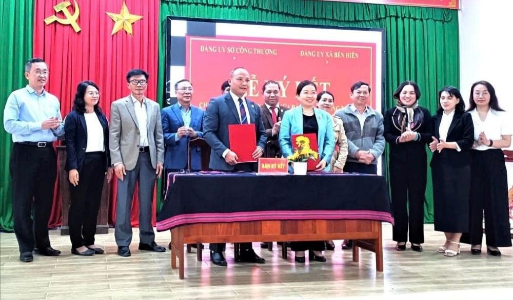 Lãnh đạo Đảng ủy xã Bến Hiên và Đảng ủy Sở Công Thương ký kết chương trình kết nghĩa. Ảnh: A TING HÀN