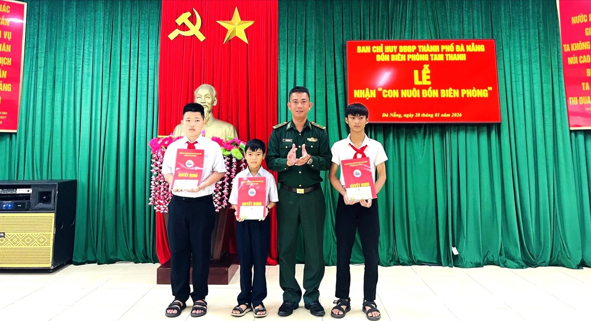 พันตรี ตรัน กว็อก คานห์ ผู้บัญชาการสถานีรักษาชายแดนตามแทง มอบเอกสารการรับบุตรบุญธรรมให้แก่นักเรียนด้อยโอกาส 3 คน ภาพ: แอล.พี.