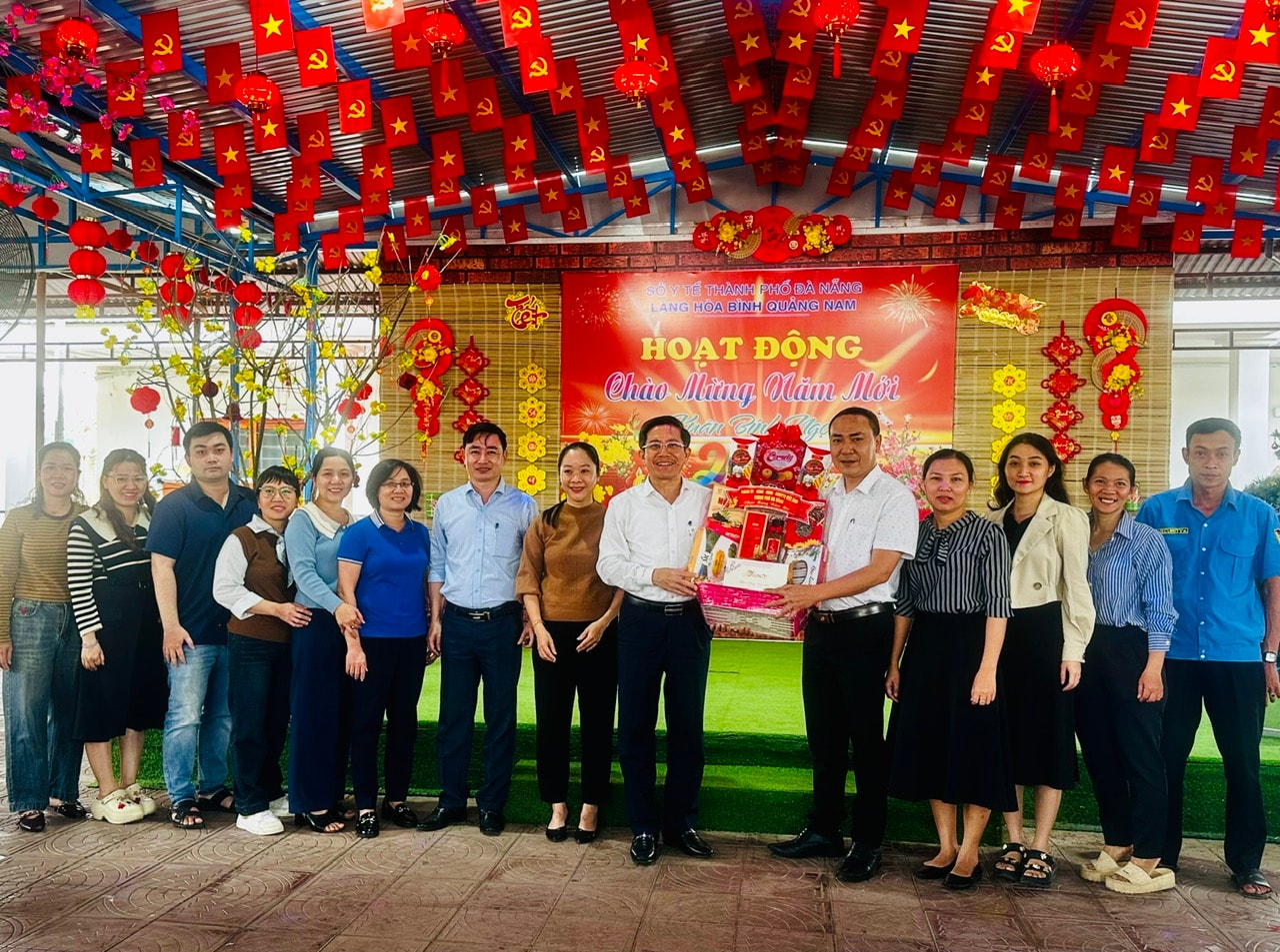 Phó Chủ tịch UBND thành phố Trần Nam Hưng (thứ 9, bên trái sang) tặng quà Tết tại Làng Hòa Bình Quảng Nam. ẢNH XUÂN HIẾU