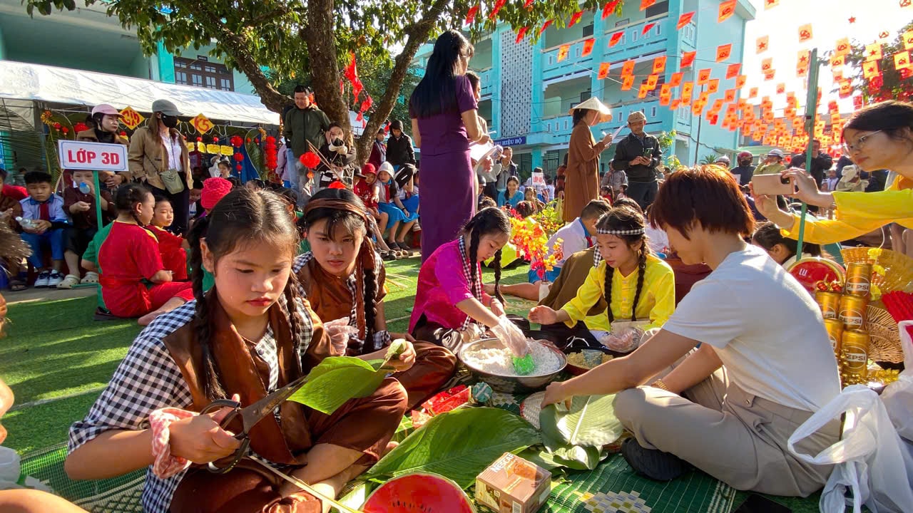 Gli studenti si cimentano nell'incartare i banh chung (dolcetti di riso tradizionali vietnamiti) per il Tet (Capodanno lunare). Foto: THU PHUONG