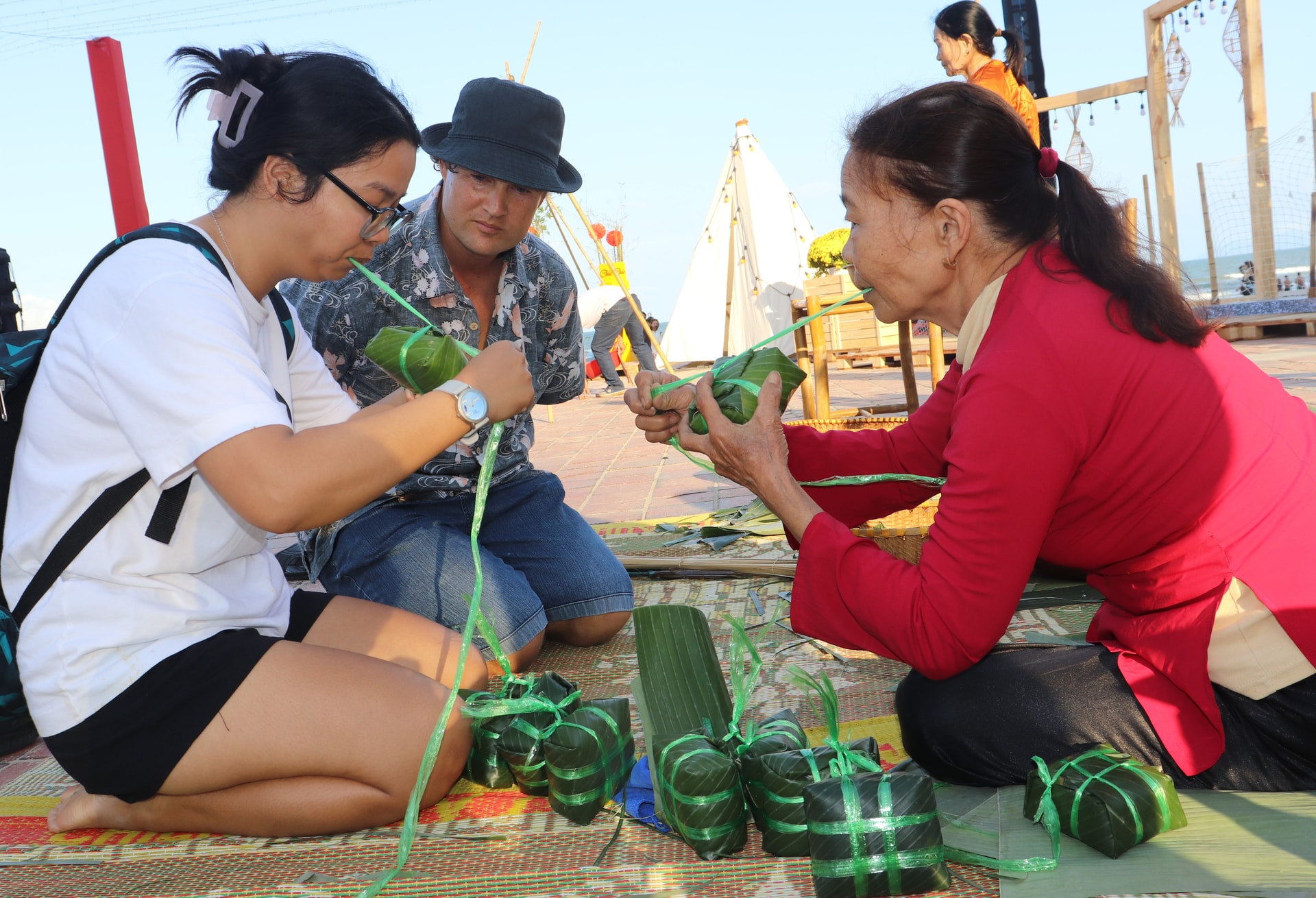 I turisti si cimentano nell'impacchettamento di banh chung e banh tet (dolcetti di riso tradizionali vietnamiti) durante il programma