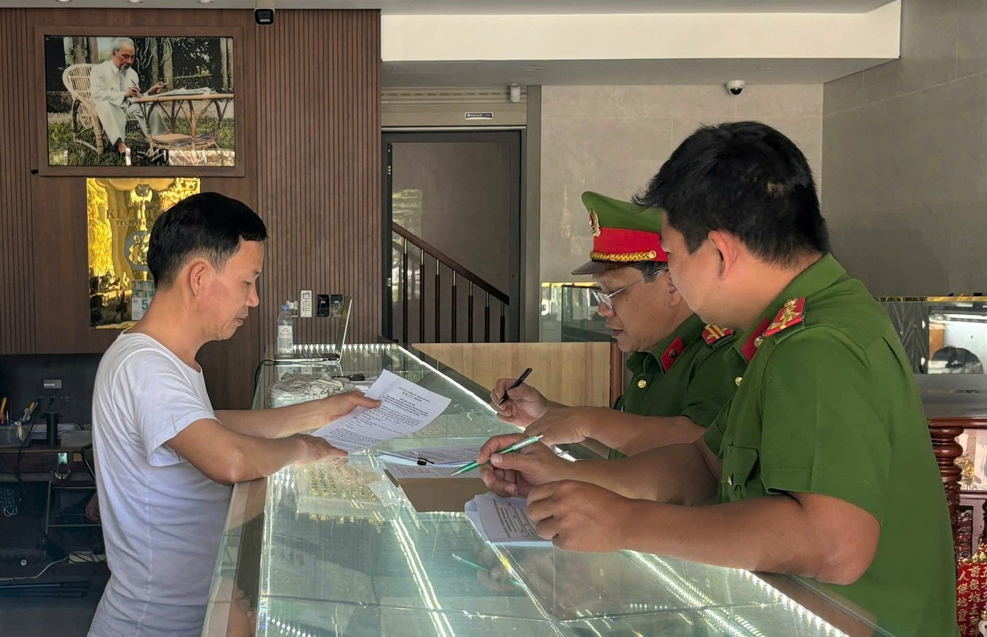 Công an phường Điện Bàn Đông tuyên truyền các biện pháp phòng ngừa tội phạm tại các ngân hàng và tiệm vàng. Ảnh: C.A
