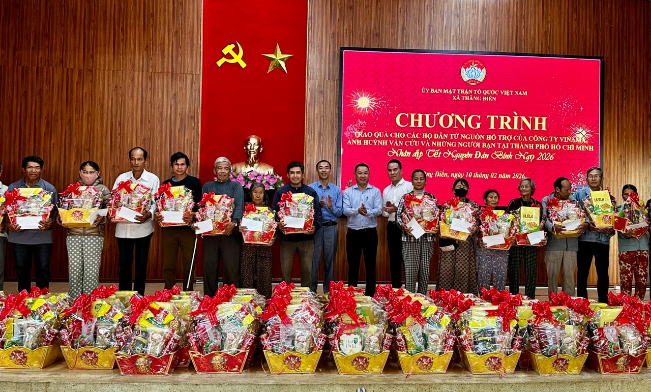 Đại diện Công ty Cổ phần Truyền thông Vinama và lãnh đạo xã Thăng Điền tặng quà cho người dân. ẢNH XUÂN HIẾU