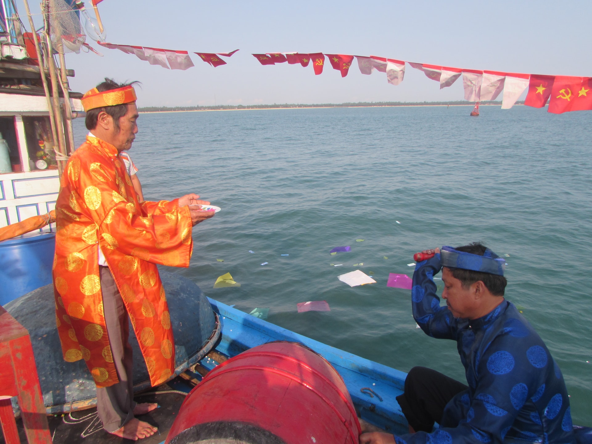 Rải vật phẩm cúng thần Nam Hải. Ảnh VĂN PHIN