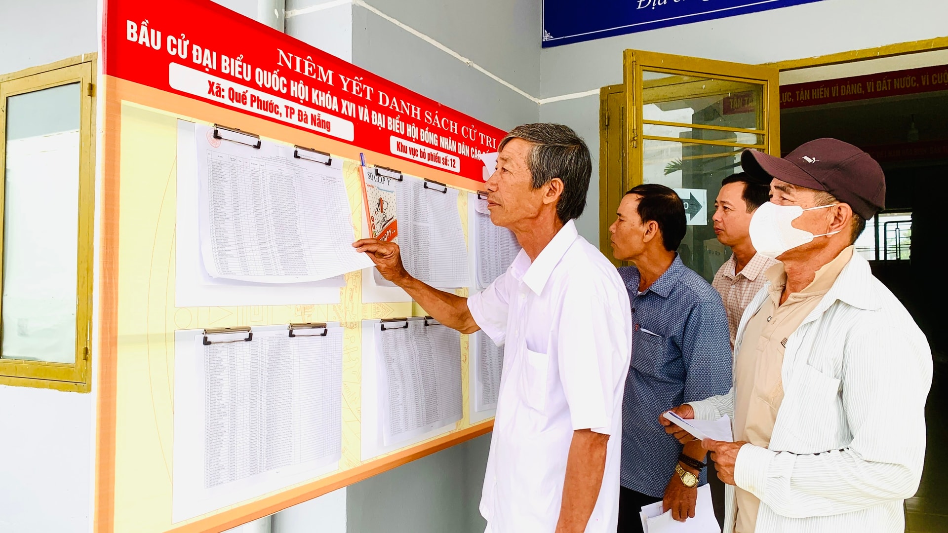 Ông Bùi Thanh Long (thôn Bình Yên, xã Quế Phước) theo dõi danh sách cử tri được niêm yết tại điểm bầu cử. Ảnh: MINH THÔNG