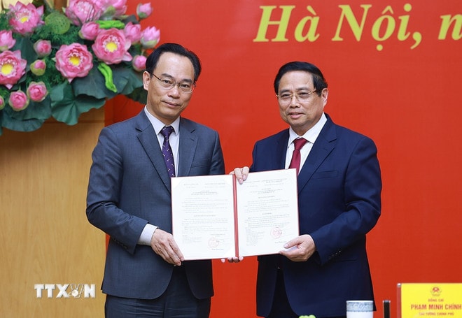 Thủ tướng Phạm Minh Chính trao Quyết định của Thủ tướng Chính phủ về việc điều động ông Hoàng Minh Sơn, Giám đốc Đại học Quốc gia Hà Nội, về công tác tại Bộ Giáo dục và Đào tạo, giao Quyền Bộ trưởng Bộ Giáo dục và Đào tạo. (Ảnh: Dương Giang/TTXVN) ttxvn-thu-tuong-trao-quyet-dinh-cong-tac-can-bo-3.jpg