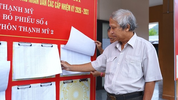 Cử tri xã Thạnh Mỹ tìm hiểu thông tin bầu cử tại điểm bỏ phiếu. Ảnh: DŨNG LOAN