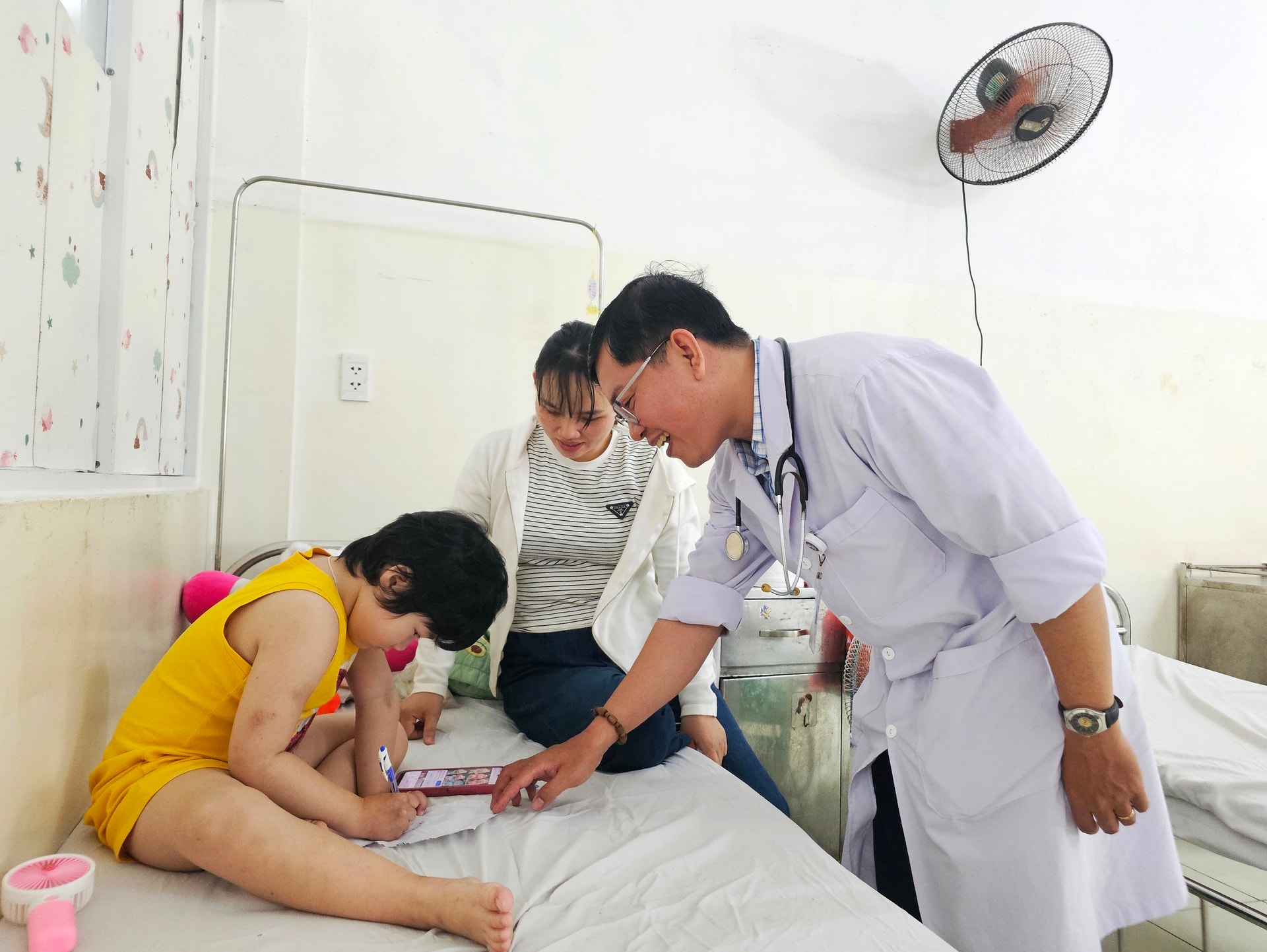 دکتر تران ون آ، معاون رئیس بخش عمومی اطفال، از کودکان بیمار تحت درمان در بیمارستان زنان و زایمان و اطفال دانانگ عیادت و آنها را تشویق می‌کند. عکس: لام فونگ