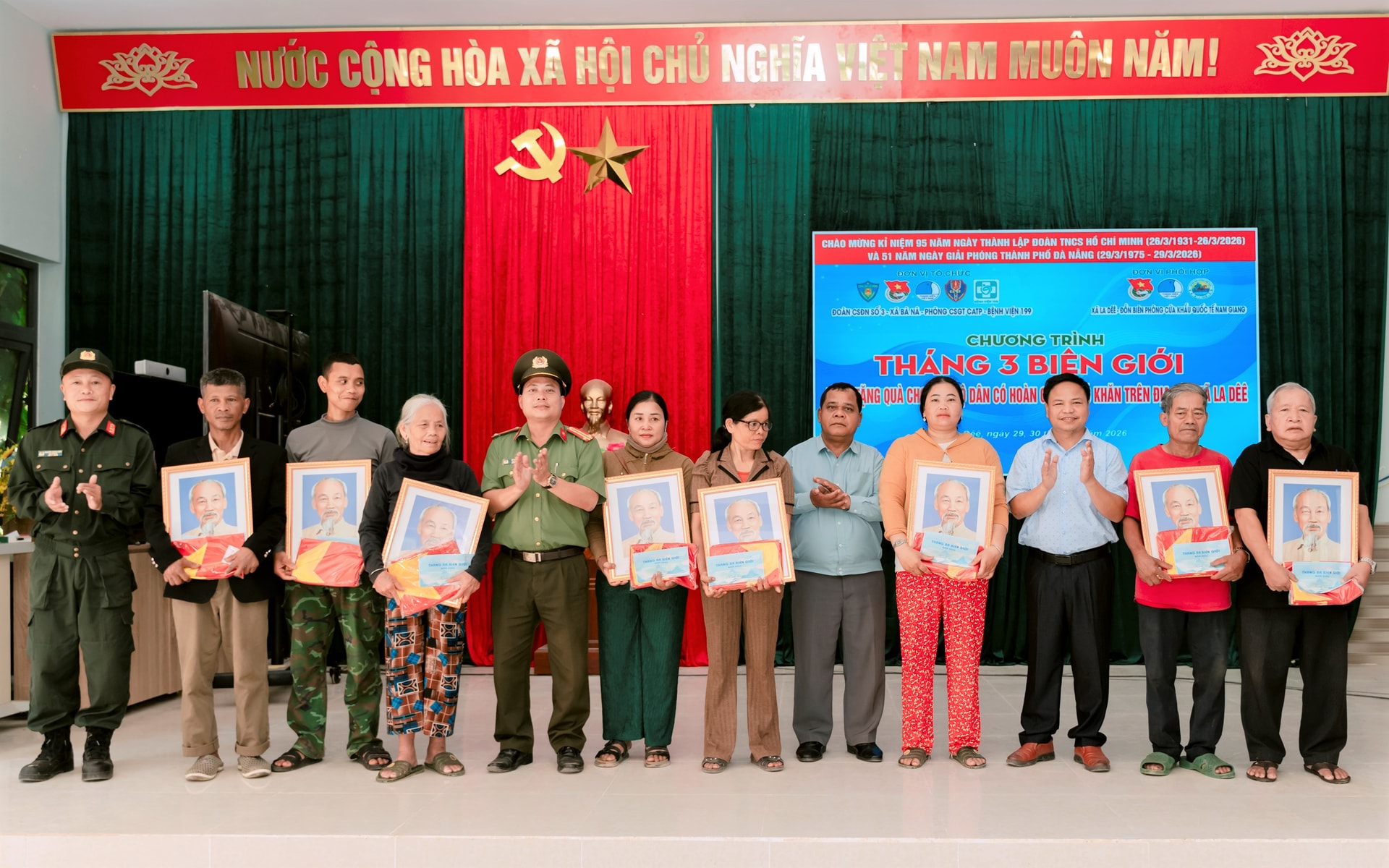 Các đơn vị tặng lá cờ Tổ quốc và chân dung Chủ tịch Hồ Chí Minh cho người dân xã biên giới La Dêê. Ảnh: QUANG TRẦN