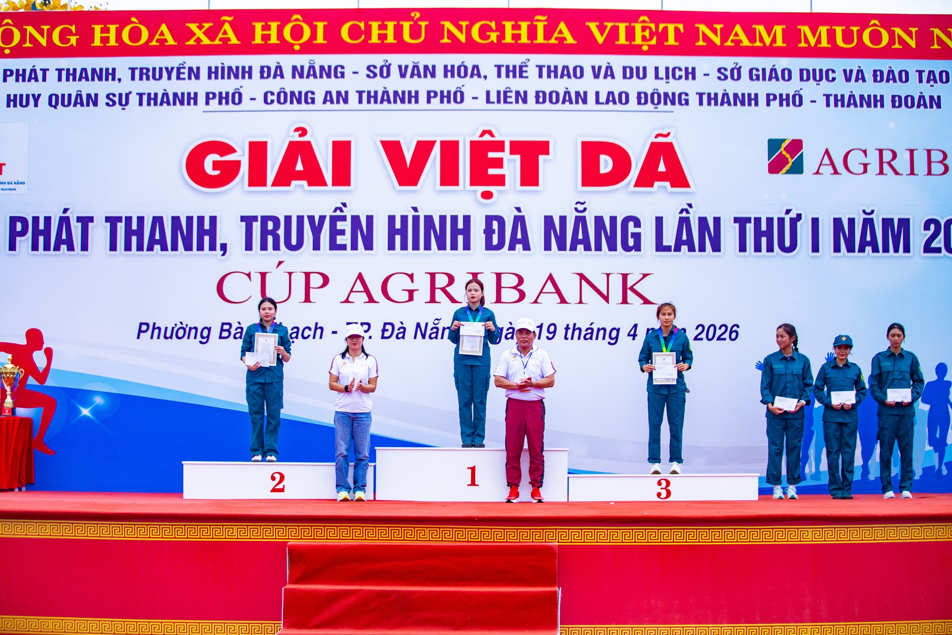 Phó Giám đốc Báo và phát thanh, truyền hình Đà Nẵng Phạm Thị Mỹ Hạnh (bên trái, hàng đầu) cùng đại diện ban tổ chức trao chứng nhận và huy chương cho vận động viên. Ảnh: LÂM NÔNG