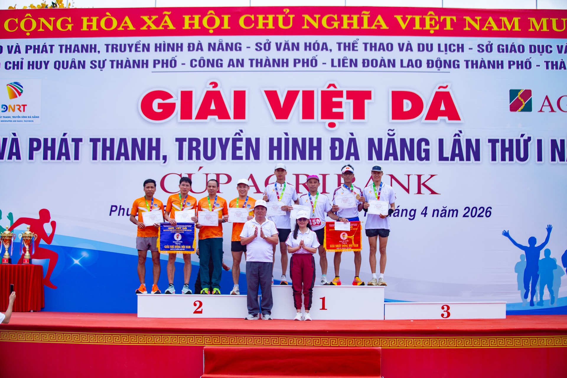 Phó Giám đốc Báo và phát thanh, truyền hình Đà Nẵng Trương Văn Nam (hàng đầu, bên trái) và Dương Nữ Hoàng Anh (hàng đầu, bên phải) trao cờ, huy chương cho vận động viên đạt giải. Ảnh: LÂM NÔNG