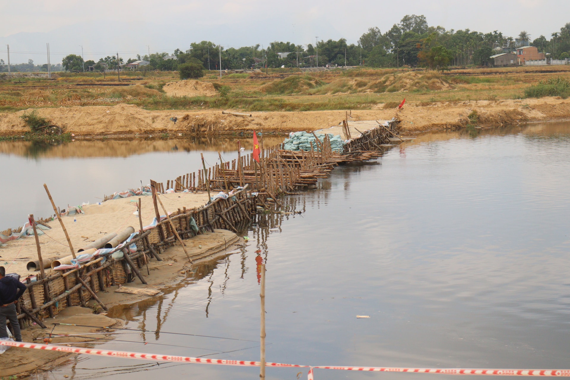 Tuyến đập tạm trên sông Vĩnh Điện chưa được hàn khẩu và hoàn thành do chưa được đẩy mặn. Ảnh: HOÀNG HIỆP