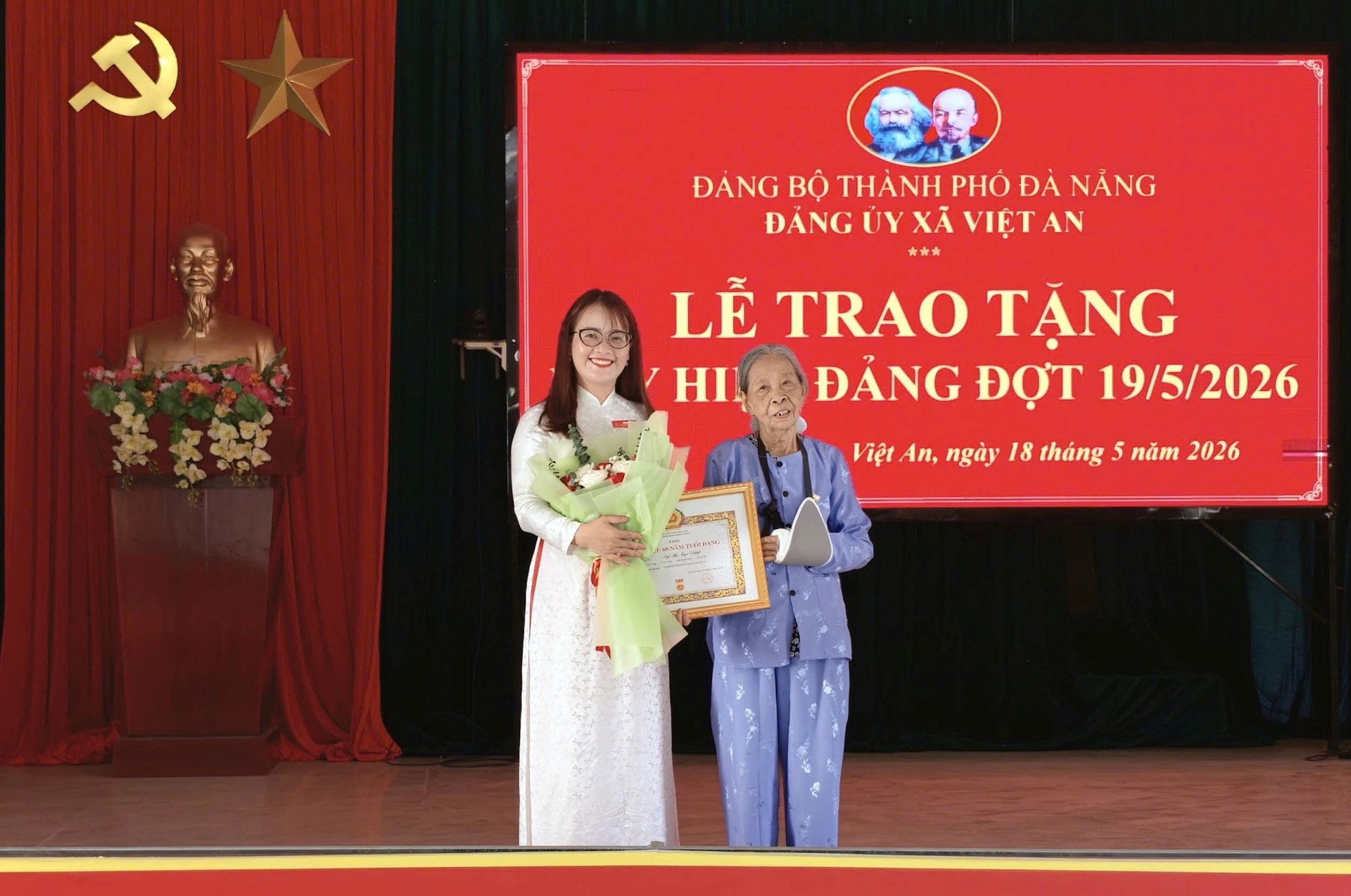 Bí thư Đảng ủy, Chủ tịch HĐND xã Việt An Trần Thị Hằng trao Huy hiệu 60 năm tuổi Đảng cho đảng viên. Ảnh: MỸ LINH