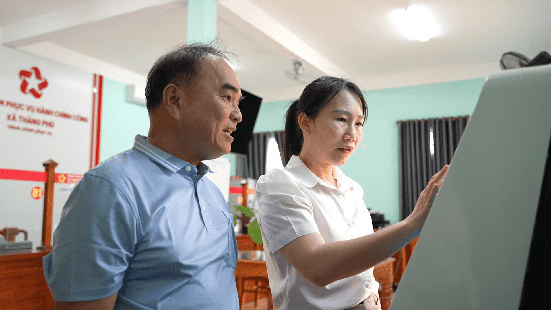 Công chức Trung tâm Phục vụ hành chính công xã Thăng Phú hướng dẫn người dân nộp hồ sơ trực tuyến. Ảnh TRUNG THỰC
