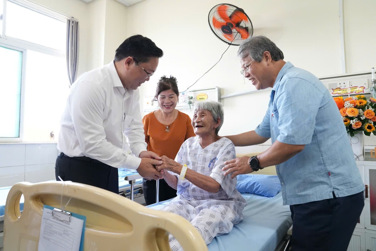 Předseda Výboru Vietnamské vlasti města Da Nang, Le Tri Thanh (zcela vlevo), a vedoucí představitelé obce Nui Thanh navštěvují a povzbuzují paní Huynh Thi Hoa (narozená v roce 1936, žijící v obci Nui Thanh), která se léčí ve Vietnamsko-korejské nemocnici v Da Nangu. Foto: HO QUAN