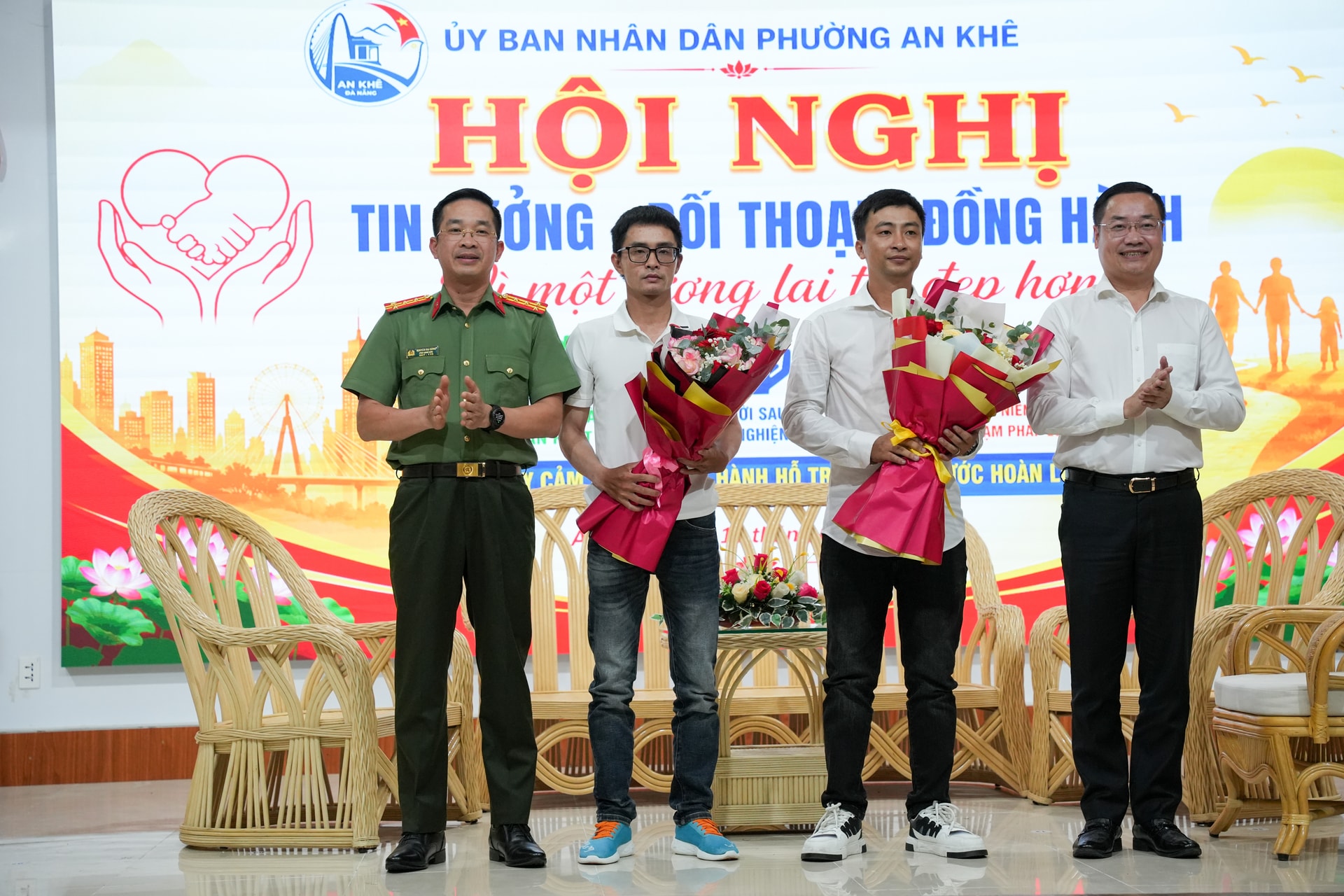Đại tá Nguyễn Đại Đồng và lãnh đạo phường An Khê tặng hoa cho hai thanh niên có nhiều nỗ lực trong tái hòa nhập cộng đồng. Ảnh: T.CÔNG 