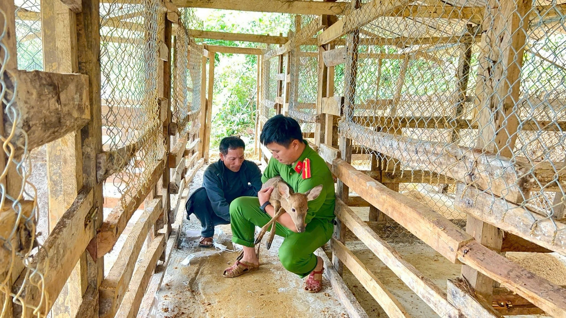 Công an xã Trà Tập hỗ trợ người dân xây dựng chuồng nuôi huơu và hướng dẫn cách chăm sóc. Ảnh: H.H