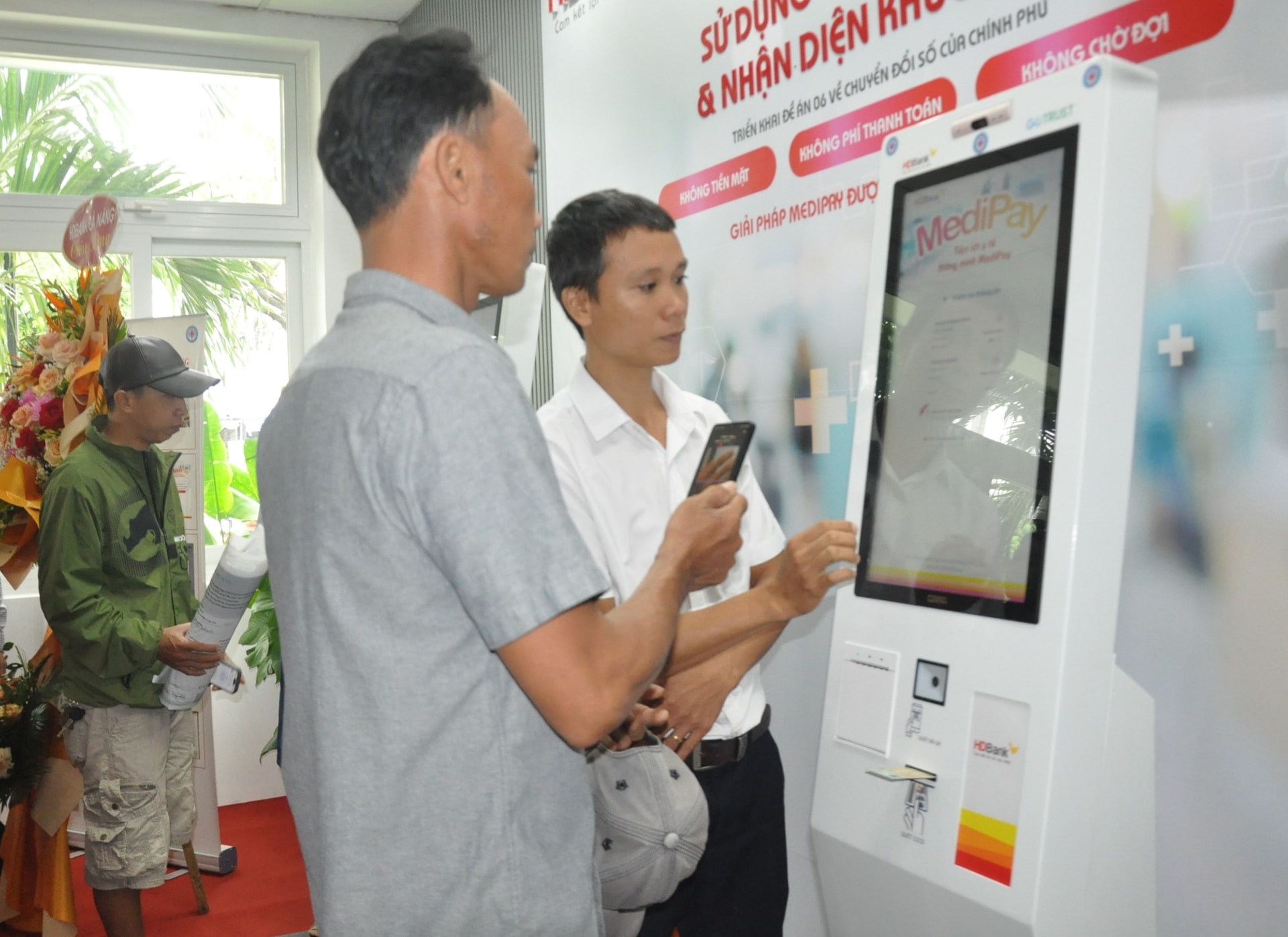 Nhân viên Bệnh viện Đà Nẵng hướng dẫn người dân đăng ký khám, chữa bệnh bằng căn cước công dân. Ảnh L.H