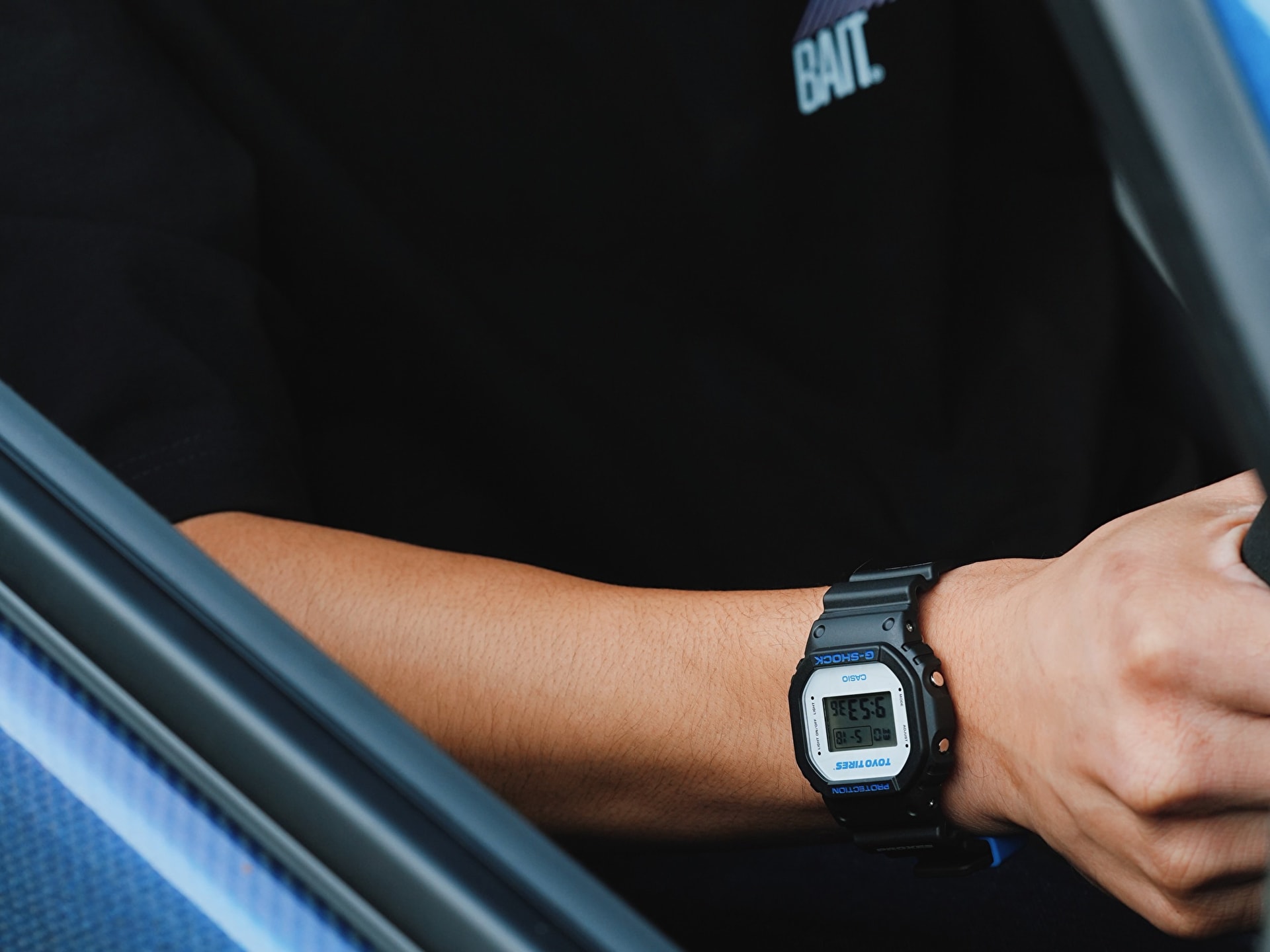 Người đeo đồng hồ Casio G-Shock DW5600TT25-1 x Toyo Tires bên trong xe hơi