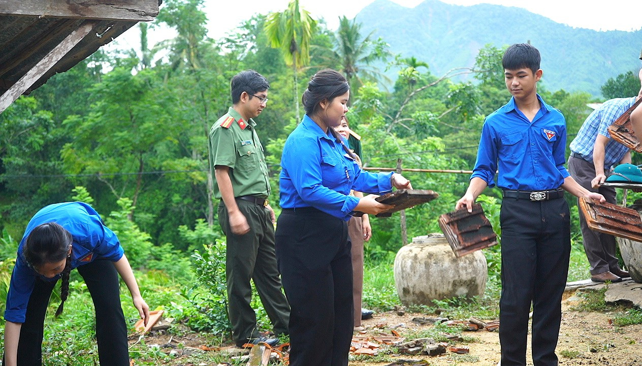 Các lực lượng xã Quế Phước hỗ trợ gia đình chính sách sửa chữa nhà ở. Ảnh: MINH THÔNG