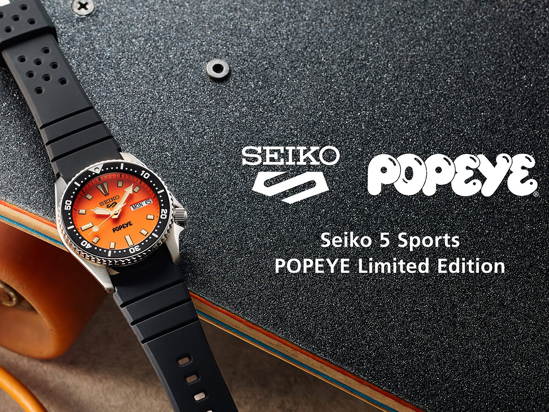 Góc nghiêng của Seiko 5 Sports x Popeye HDB013 cho thấy mặt số cam và vòng bezel đen