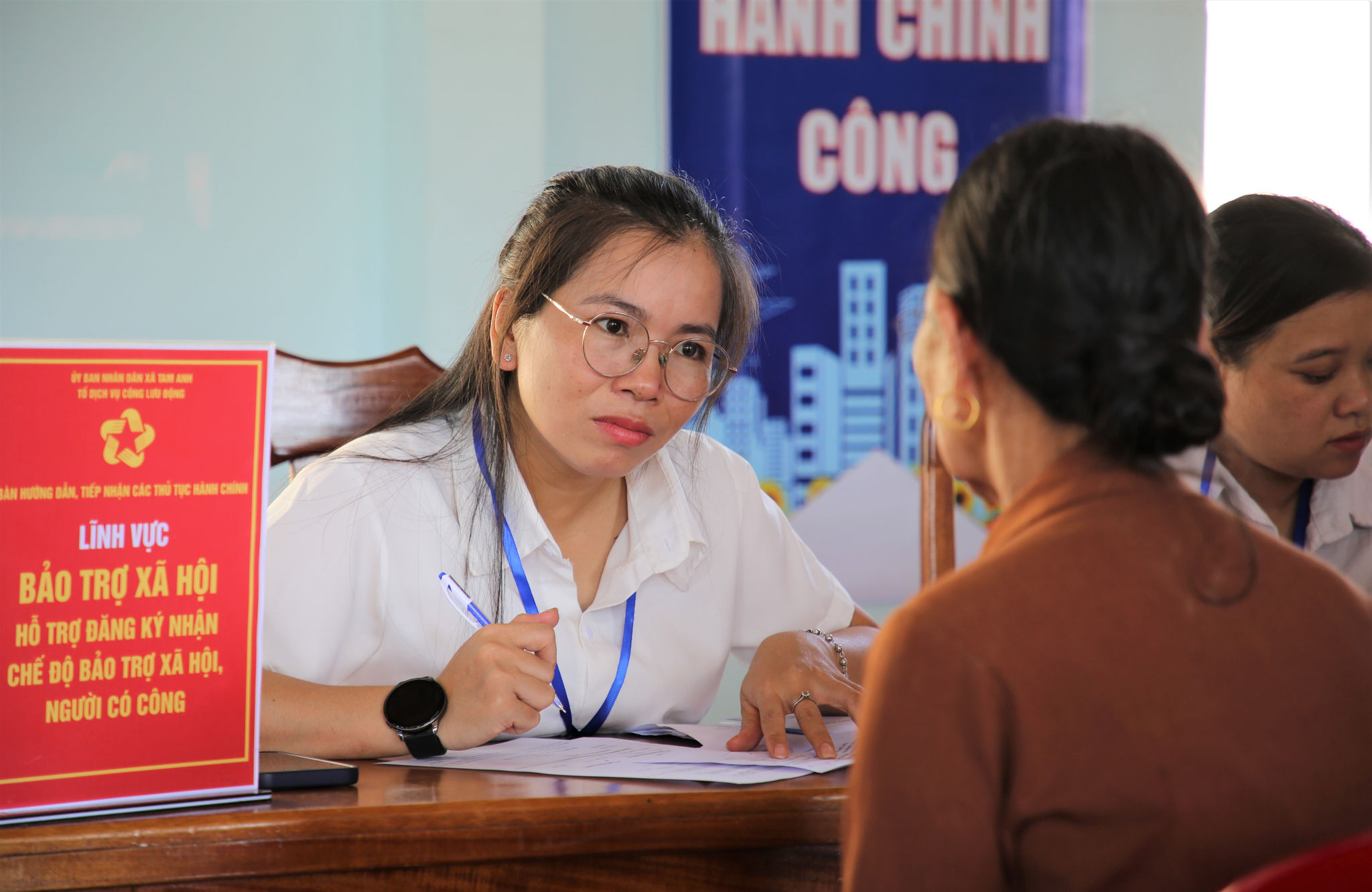 Cán bộ, đảng viên xã Tam Anh hỗ trợ người dân thực hiện thủ tục hành chính tại cơ sở. Ảnh: ALĂNG NGƯỚC