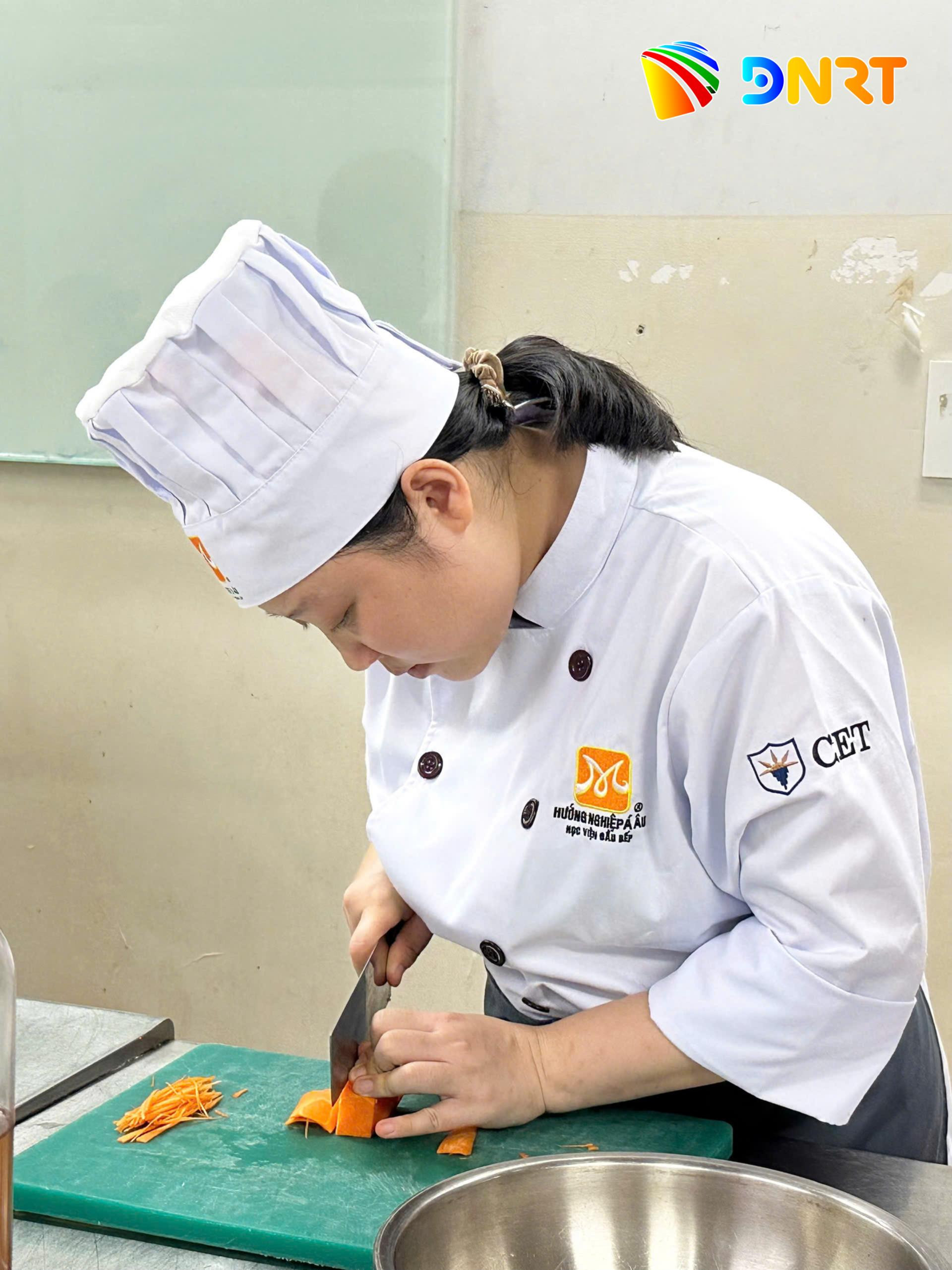 Chị Nguyễn Hoàng Tiểu Đào chăm chú thực hiện từng công đoạn trong buổi học nghề bếp. Ảnh: NAM BÌNH