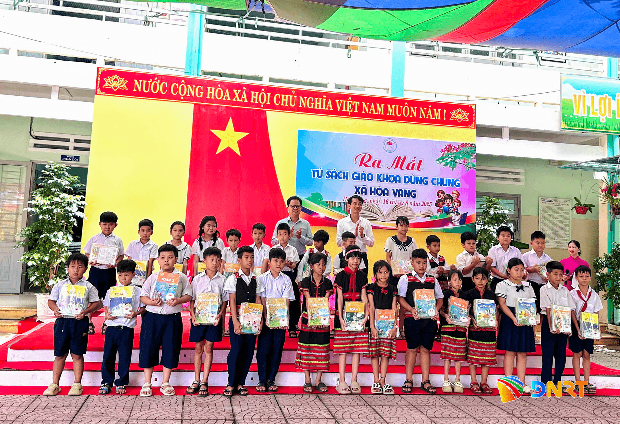 Học sinh Hòa Vang hân hoan nhận sách ngày ra mắt Tủ sách dùng chung xã Hòa Vang. Ảnh: SANG THU