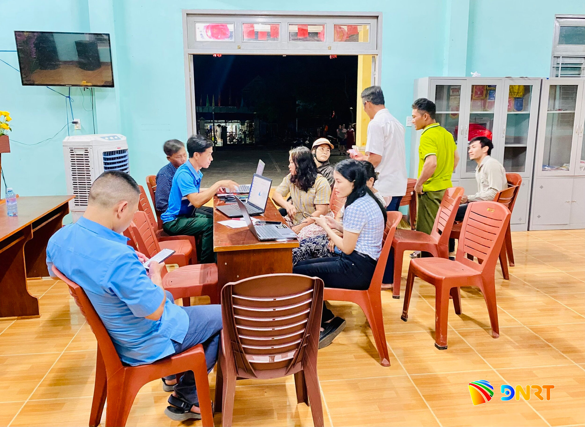 Ảnh 1. Cán bộ đến trụ sở thôn cài đặt và hướng dẫn đảng viên sử dụng sổ tay đảng viên điện tử vào buổi tối