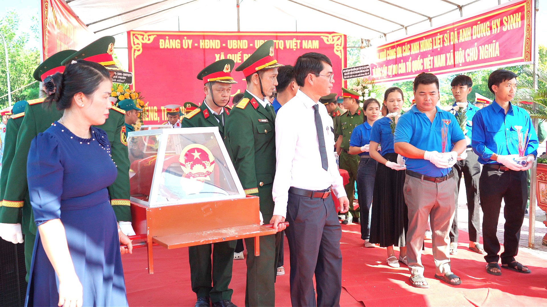 Đại diện lãnh đạo Sở Nội vụ và lãnh đạo xã Quế Phước đưa hài cốt liệt sĩ về nơi an nghỉ. Ảnh: MINH THÔNG