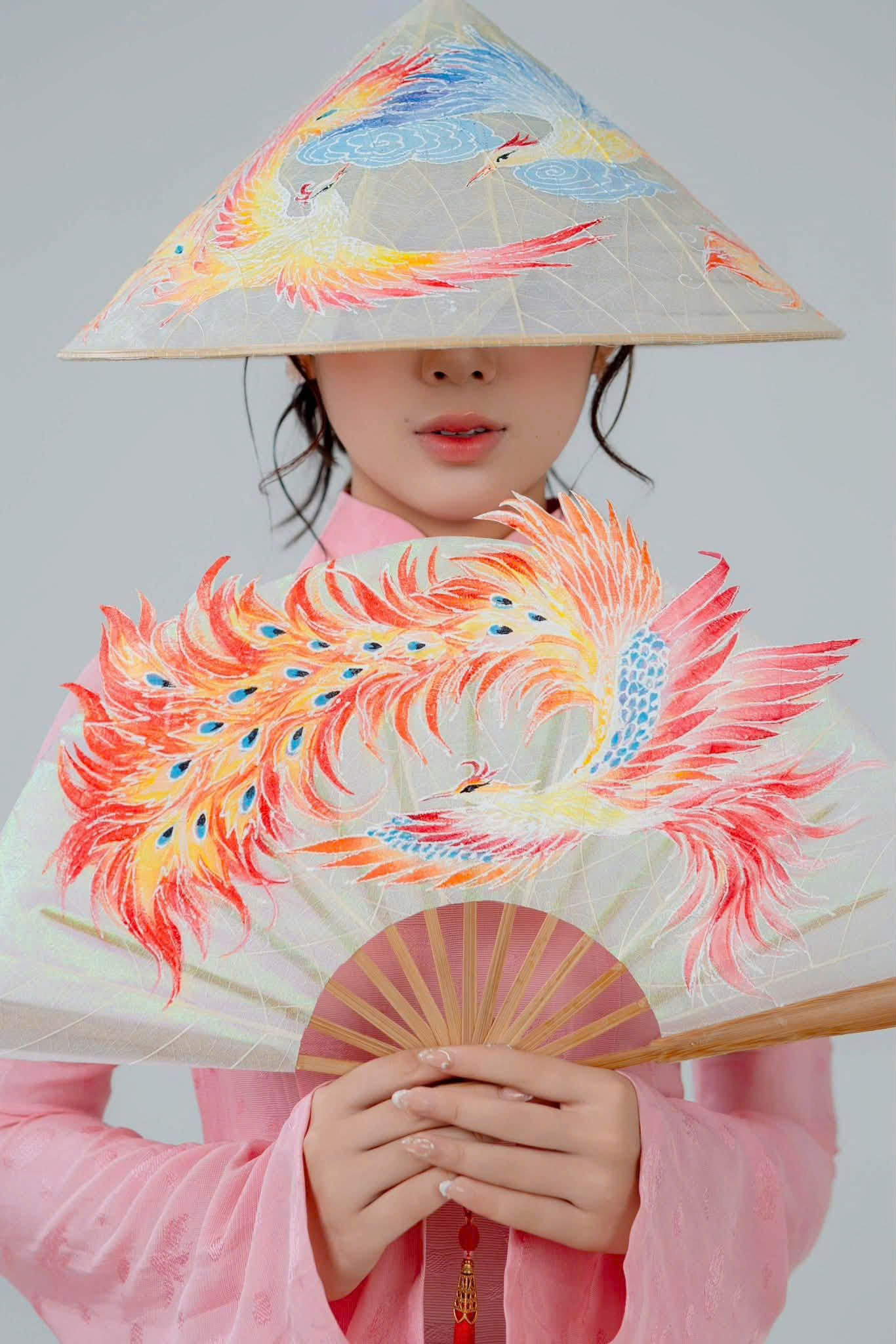 Conical hats and leaf-skeleton fans crafted by Vo Thi Nhu Nguyen are showcased at the Ao Dai Fashion Week London 2026. Photo: Ao Dai Fashion Week London 2026 Organising Committee