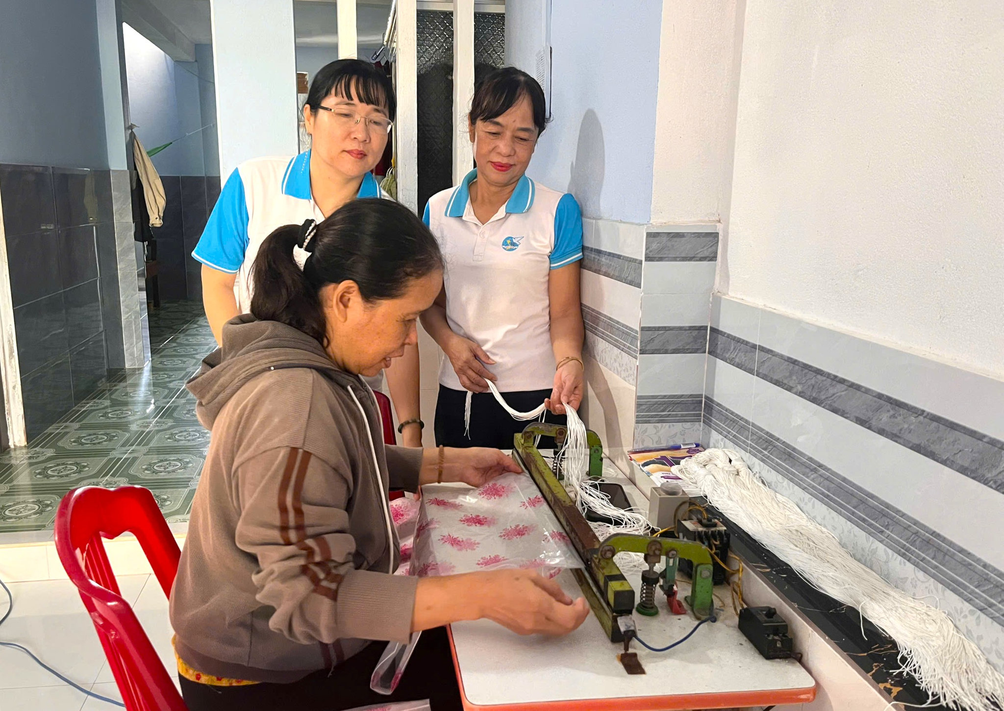 Hội Liên hiệp Phụ nữ xã Nam Phước tặng chị Ngô Thị Bình (thôn Xuyên Tây) máy dập áo mưa để ổn định sinh kế. Ảnh: NGỌC QUỐC