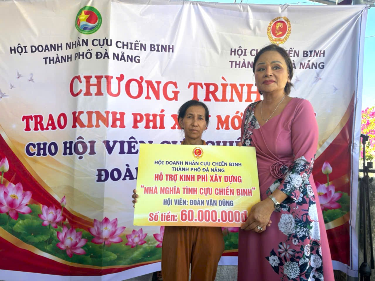 Bà Hồ Thị Thắng (bên phải) trao 60 triệu đồng hỗ trợ xây dựng nhà cho gia đình cựu chiến binh Đoàn Văn Dũng (xã Thăng An). Ảnh: XUÂN ĐÔNG