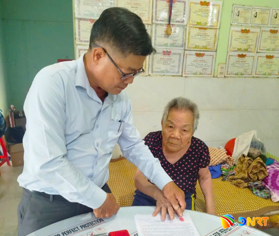 Cán bộ xã Hòa Tiến hỗ trợ giải quyết thủ tục hành chính tại nhà cho người cao tuổi. Ảnh: NGỌC QUỐC