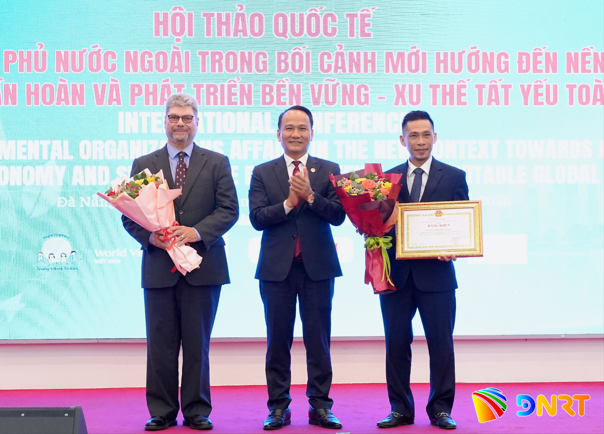 Phó Bí thư Thành ủy, Chủ tịch Ủy ban MTTQ Việt Nam thành phố Nguyễn Đình Vĩnh (giữa) trao Bằng khen của UBND thành phố tặng tổ chức Catalyste+ (Canada). Ảnh: T.CÔNG