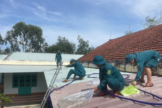 Dân quân xã Thăng An hỗ trợ chằng chống nhà cửa, trường học ứng phó bão số 13