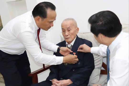 Phó Bí thư Thường trực Thành ủy Đà Nẵng Nguyễn Đình Vĩnh trao Huy hiệu 80 năm tuổi Đảng cho đảng viên Hoàng Bá Lâm