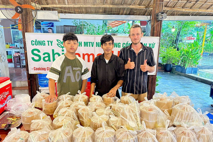 Foreign tourists join locals in cooking free meals for Hoi An flood victims